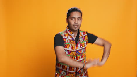 Man-doing-entertaining-bollywood-dance-moves,-studio-background