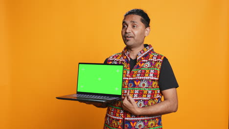 Tech-content-creator-doing-influencer-marketing-using-green-screen-laptop