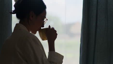 Silhouette-Einer-Frau,-Die-Kaffee-Am-Fenster-Trinkt