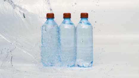 Botellas-De-Agua-Potable-Fresca-En-Agua-Azul-Salpicada.-Filmada-Con-Una-Cámara-En-Cámara-Súper-Lenta-De-1000-Fps.