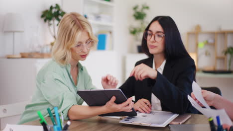 Las-Mujeres-Discuten-El-Proyecto-Sobre-La-Tableta-Digital-En-La-Oficina.