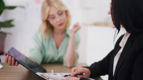 Woman-Writes-Important-Info-in-Notebook-During-Business-Meeting