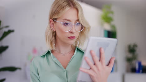 Businesswoman-with-Glasses-Analyzes-Sales-Reports-on-Tablet