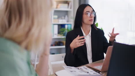 Mujer-De-Negocios-Con-Gafas-Habla-Con-Su-Colega