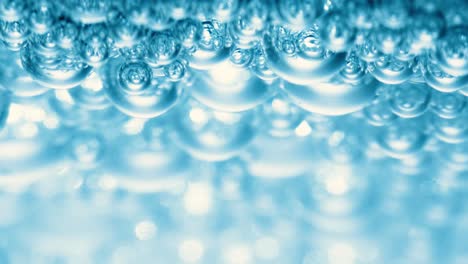 Many-water-bubbles-in-blue-water-close-up,-abstract-water-wave-with-bubbles-in-slow-motion.