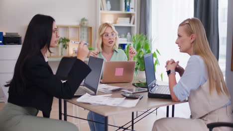 Drei-Frauen-Diskutieren-Geschäftsprojekt-Während-Der-Besprechung