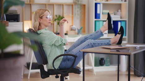 Pensive-Happy-Businesswoman-with-Legs-on-Desk