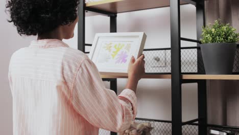 Mujer-Feliz-Decorando-Su-Casa-Con-Una-Foto-En-Un-Marco.-Mejoras-Para-El-Hogar,-Decoración-Y-Concepto-De-Personas-Mujer-Feliz-Decorando-Su-Habitación-Con-Una-Foto-En-Un-Marco