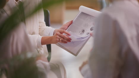 Close-Up-of-Woman's-Hand-Gesturing-Over-Financial-Report