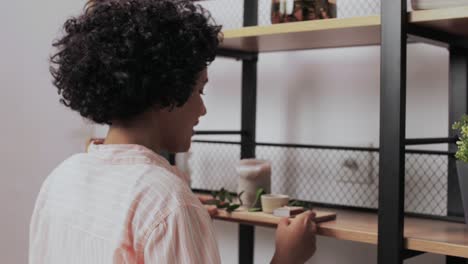 Woman-with-Matchsticks-Lighting-Candles-at-Home.home-improvement,-decoration-and-people-concept--woman-with-matchsticks-lighting-candles-on-shelf