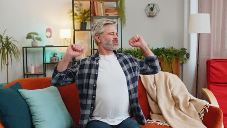 Un-Hombre-Cansado-De-Mediana-Edad-Estirando-Los-Brazos-Y-Descansando-Relajándose-En-El-Sofá-De-La-Sala-De-Estar-En-Casa