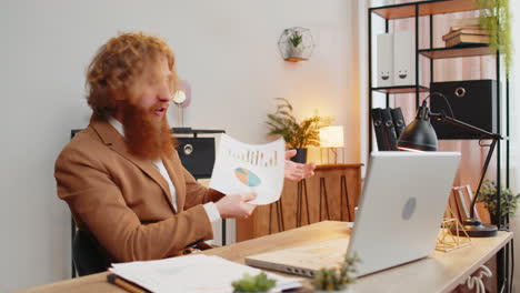 Verärgerter-Geschäftsmann-Streitet-über-Laptop,-Ruft-Online-An-Und-Zeigt-Diagramme-Von-Berichten-Am-Home-Office-Tisch-An