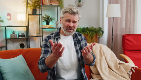 Dissatisfied-mature-man-arguing-talking-on-video-call-complains-about-problems-looking-in-camera