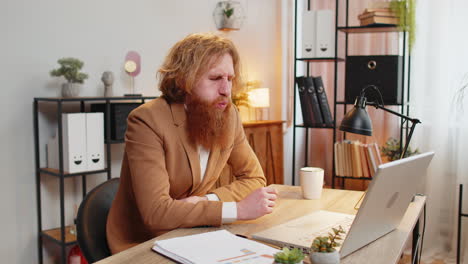 Kranker-Mann,-Der-Beim-Überessen-Schmerzen-Hat-Und-Den-Magen-Berührt,-Während-Er-Am-Laptop-Im-Home-Office-Arbeitet