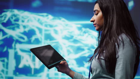 Close-up-shot-of-computer-scientist-using-tablet-in-AI-company-workspace