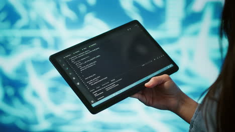 Close-up-shot-of-computer-scientist-using-tablet-in-AI-company-workspace