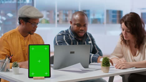 Clients-discussing-with-the-contractor-next-to-green-screen-on-tablet