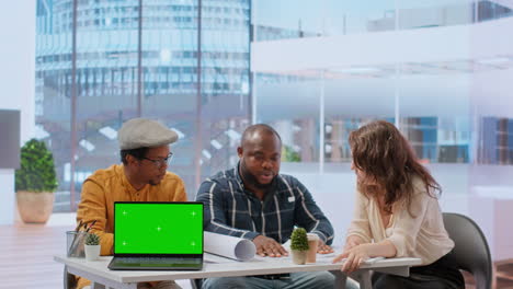 Diverse-people-meeting-on-an-office-tour-next-to-laptop-with-green-screen