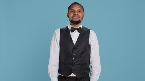 Friendly-bellman-porter-with-suit-and-tie-waving-at-hotel-guests