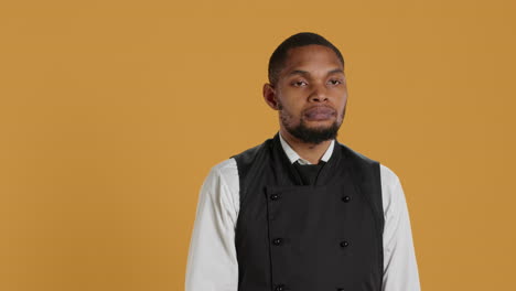 Restaurant-staff-giving-a-thumbs-down-sign-against-yellow-background