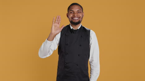 Skilled-waiter-waving-and-greeting-clients-at-five-star-restaurant