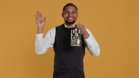 Happy-friendly-waiter-waving-hello-and-welcoming-clients-at-table