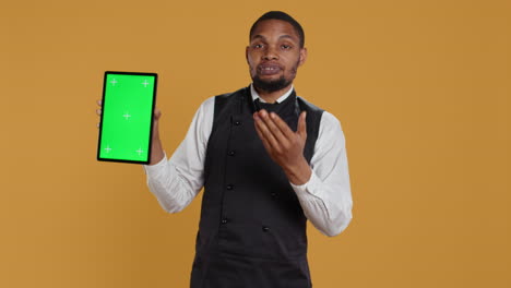 Waiter-showing-a-tablet-with-isolated-copy-space-in-studio