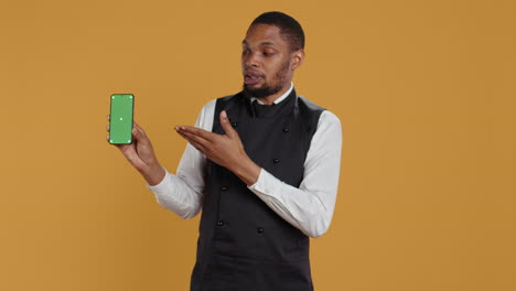 Restaurant-staff-showing-a-smartphone-with-green-screen-in-studio,