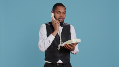 Bellboy-concierge-staff-answering-landline-phone-call-to-make-reservations