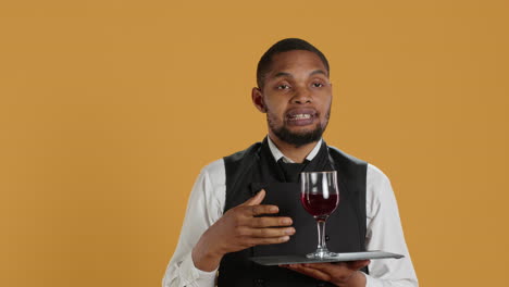 Waiter-serving-clients-with-a-glass-of-red-wine-before-dinner