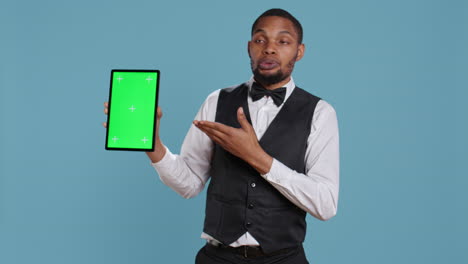 Bellman-hotelier-showing-a-tablet-with-green-screen-display-in-studio