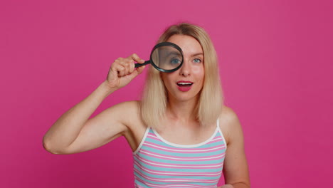 Amazed-excited-woman-hold-magnifying-glass-near-face-looking-at-camera-with-big-zoomed-eye-analyzing