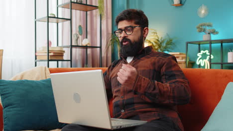 Amazed-Indian-man-use-laptop-computer,-receive-good-news-message-shocked-by-victory,-celebrate-win