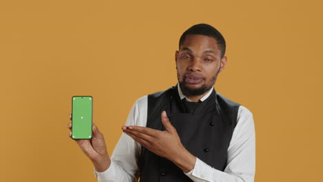 Restaurant-staff-showing-a-smartphone-with-green-screen-in-studio,