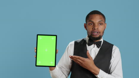 Bellman-hotelier-showing-a-tablet-with-green-screen-display-in-studio