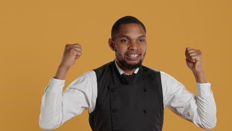 Waiter-flexing-his-muscles-and-showing-his-strength-in-studio