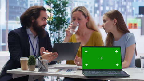 Financial-advisor-presents-financial-guide-to-clients-using-green-screen-laptop