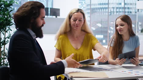 Mother-and-daughter-writing-signature-on-paperwork-to-receive-loan