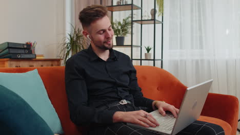 Guy-sitting-on-home-couch,-looking-at-camera,-making-video-conference-call-with-friends-or-family