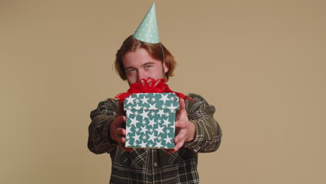 Un-Hombre-Sonriente-Que-Presenta-Una-Caja-De-Regalo-De-Cumpleaños-Extiende-Las-Manos-Y-Ofrece-Un-Bono-De-Carrera-Presente-Envuelto