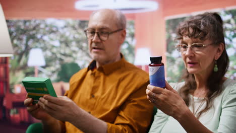 Senior-couple-looking-at-pills-and-vitamins-in-boxes-and-bottles