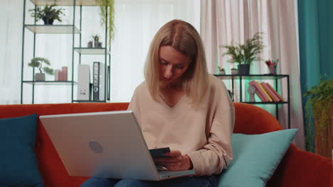 Girl-student-study-at-home-couch-on-laptop-computer-making-conference-video-call-talking-to-webcam