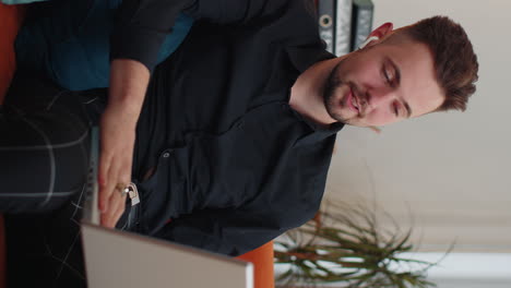 Guy-sitting-on-home-couch,-looking-at-camera,-making-video-conference-call-with-friends-or-family