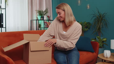 Glückliche-Junge-Käuferin-Packt-Karton-Aus,-Lieferung-Von-Paketen,-Online-Shopping-Kauf-Zu-Hause