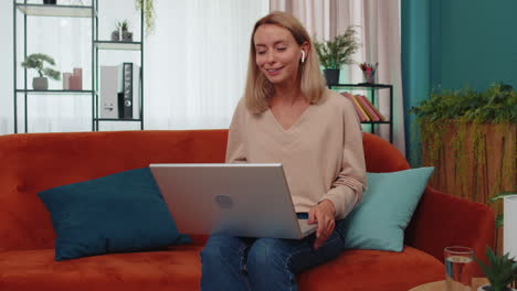 Woman-sitting-on-home-couch,-looking-at-camera,-making-video-conference-call-with-friends-or-family