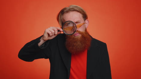 Investigator-researcher-man-with-magnifying-glass-near-face,-looking-into-camera-with-big-zoom-eye