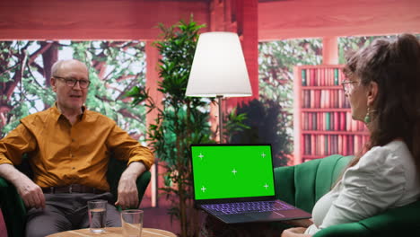 Mature-people-enjoying-leisure-time-at-home-with-green-screen-on-laptop