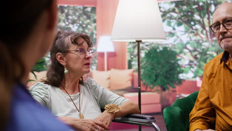 Social-caretaker-consulting-elderly-woman-in-wheelchair-during-a-home-visit