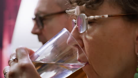 Senior-woman-swallowing-her-pills-with-a-glass-of-water-at-home,