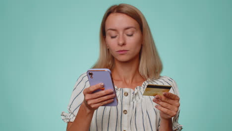 Young-woman-using-credit-bank-card-and-smartphone-while-transferring-money-purchases-online-shopping